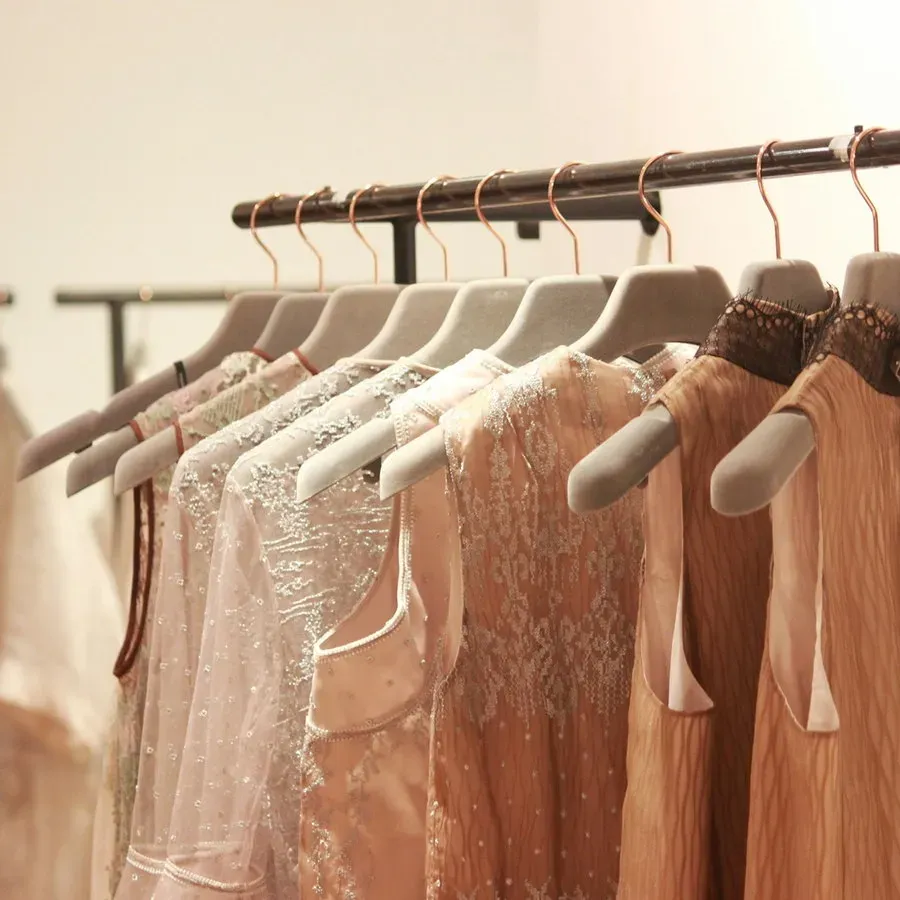 Garments in warm neutral tones hanging on a clothing rail